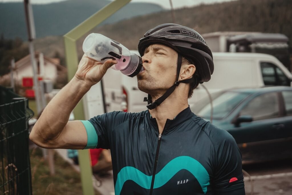 Wielrenner drinkt onderweg uit een sportbidon met sportdop tijdens een fietstocht